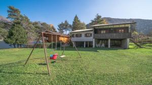 a yard with two swings in front of a house at Bungalow al Lago in Ledro