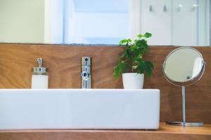 a bathroom counter with a mirror and a sink at Alenti Sitges Hotel in Sitges