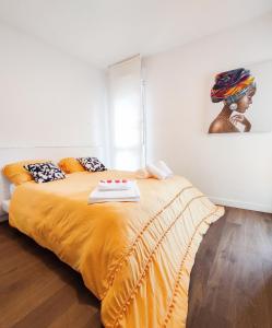 - une chambre avec un grand lit et une couverture jaune dans l'établissement T3 au centre ville avec balcon, parking gratuit, à Quimper