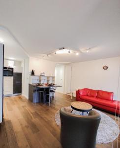 a living room with a red couch and a kitchen at T3 au centre ville avec balcon, parking gratuit in Quimper
