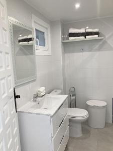 Baño blanco con aseo y lavamanos en Seaside apartment Atlantico Arenal-Bol Calpe, en Calpe