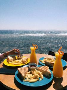 a table with plates of food on a table with a view at Happy Land Hotel Dahab in Dahab