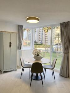 comedor con mesa, sillas y ventana en Seaside apartment Atlantico Arenal-Bol Calpe, en Calpe