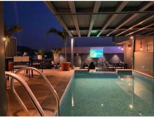 a swimming pool with chairs and a television on a building at Ka10 SQUARE HOTEL & BANQUETS in Jaipur