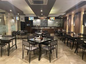 a dining room with tables and chairs in a restaurant at Ka10 SQUARE HOTEL & BANQUETS in Jaipur