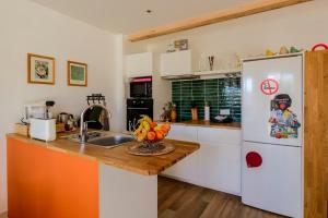 a kitchen with a sink and a refrigerator at Le Cabanon de Virginie in Salin-de-Giraud