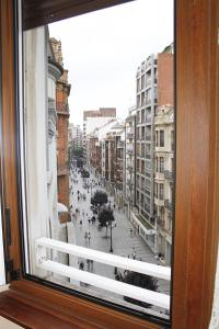 una ventana con vistas a una calle de la ciudad en Apartamento en el corazón de Gijón con parking incluido, VUT 78 en Gijón