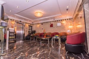 a waiting room with red leather chairs and tables at Victoria Hotel in Dubai +2 photos