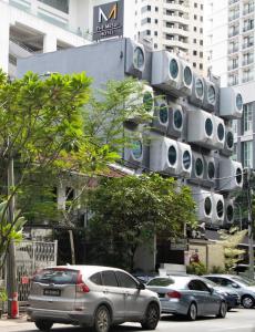 Ein Gebäude mit einem Haufen Autos, die auf einer Straße geparkt sind. in der Unterkunft The Mesui Hotel Bukit Bintang in Kuala Lumpur
