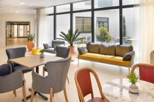 a living room with a couch and a table and chairs at Domitys - La Majolique in Béziers