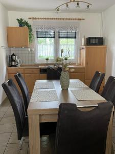 a kitchen with a wooden table and black chairs at Ferienhaus Strandoase in Zingst