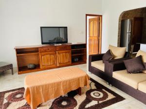 a living room with a television on a wooden entertainment center at Ocean Blue Bay in Anse Volbert Village