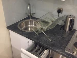 a kitchen counter with a sink and a fan on it at Showcase Apartments – Kimberley House in Leicester
