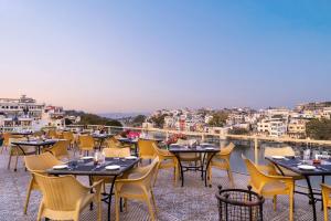 a row of tables and chairs on a roof at Hotel Sarovar On Lake Pichola in Udaipur