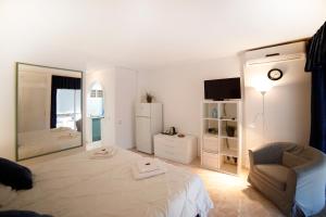 a bedroom with a bed and a chair and a mirror at Apartamentos DC in Benalmádena
