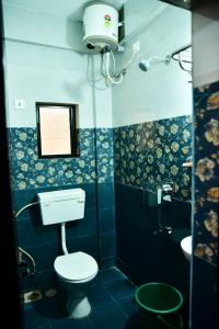 y baño con aseo, lavabo y espejo. en INDRAYANI GUEST HOUSE, en Calangute