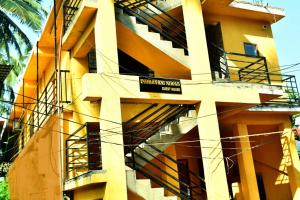 un edificio amarillo con una escalera de incendios. en INDRAYANI GUEST HOUSE en Calangute