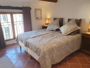 Un dormitorio con una cama grande con almohadas. en La Maison Provençale, en La Roquebrussanne