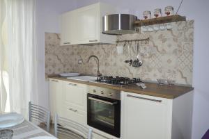 a small kitchen with a stove and a sink at Homiday - Residenza D'Annunzio in Pineto