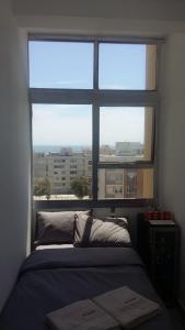 a bedroom with a bed and a large window at Modern rooms available close to the beach in Humewood in Port Elizabeth