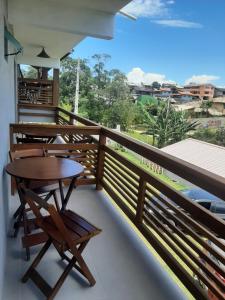 a balcony with tables and chairs and a view at Pousada Vielas do Rosa - centrinho da praia do rosa in Praia do Rosa