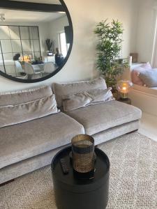 uma sala de estar com um sofá e um espelho em great seaview apartment em Knokke-Heist