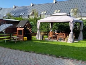 a white gazebo in a yard with a dog house at Morska Kryjówka in Niechorze