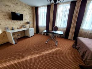 スタヴロポリにあるHotel Oneginのベッド、デスク、テレビが備わる客室です。