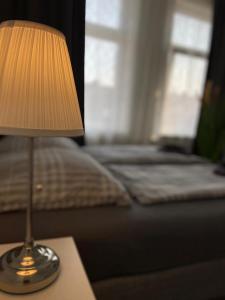 una lámpara sentada en una mesa junto a una cama en City Pension Bremerhaven, en Bremerhaven