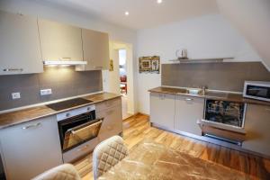 a kitchen with stainless steel appliances and wooden floors at Turis Ferienwohnung 65-3 in Triberg