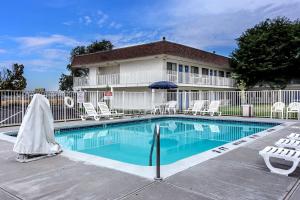 a swimming pool in front of a building with chairs and a fence at Motel 6 Ontario, OR in Ontario