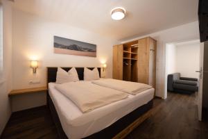 um quarto com uma cama grande e uma cadeira em Appartement Hammerrain em Flachau