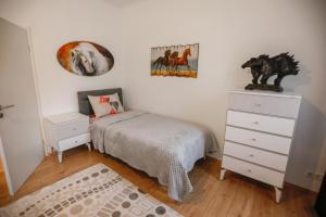 um quarto com uma cama, uma cómoda e pinturas em Turis Ferienwohnung 65-1 em Triberg