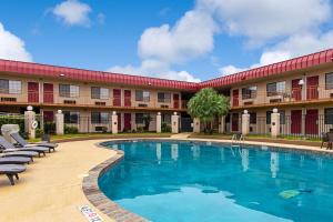 a hotel with a swimming pool in front of a building at Econo Lodge Kingsville in Kingsville