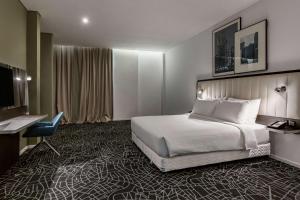 Habitación de hotel con cama y escritorio en Radisson Hotel & Apartments Dammam Industry City, en Dammam