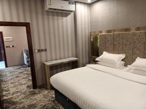 ein Hotelzimmer mit einem großen Bett und einem Spiegel in der Unterkunft حياة تاون البدع in Al Bad‘