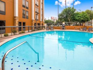 a large blue swimming pool in a hotel courtyard at Clarion Pointe near Medical Center in San Antonio