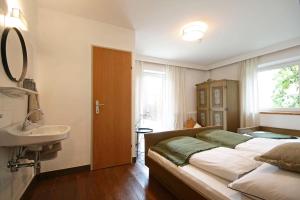 een slaapkamer met een bed, een wastafel en een raam bij Almliesl NEUK-662 in Neukirchen am Großvenediger