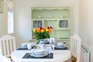 una mesa de comedor con un jarrón de flores. en Stable View, Clara Meadows Dunfanghy, en Dunfanaghy