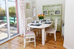 a dining room with a white table and chairs at Stable View, Clara Meadows Dunfanghy in Dunfanaghy