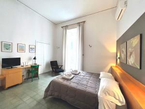 a bedroom with a bed and a desk and a television at B&B Il Sorriso in Naples