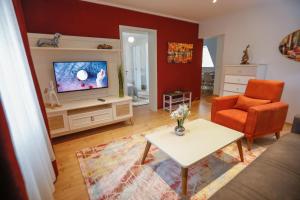 Turis Ferienwohnung 65-4 في تيبرغ: غرفة معيشة مع أريكة وتلفزيون