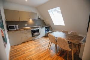 uma cozinha com uma mesa de madeira e cadeiras num quarto em Turis Ferienwohnung 65-4 em Triberg