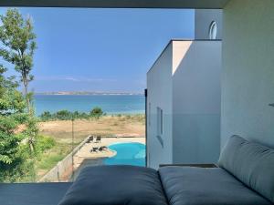 a living room with a couch and a view of the ocean at Aparthotel Dalmacija in Privlaka