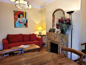a living room with a red couch and a fireplace at Zassiettes et titin in Dijon