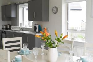 una cucina con un tavolo con un vaso di fiori sopra di The Palm, Cnoc na Gaoithe, Dunfanaghy a Dunfanaghy