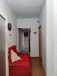 a living room with a red couch and a hallway at aparment puerto Alto in Madrid