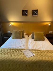 Una habitación de hotel con dos camas con certificados. en Hotel Het Anker en Heythuysen
