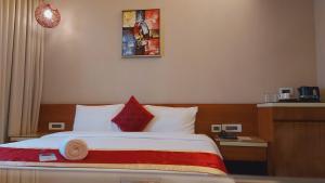 a hotel room with a bed with red and white pillows at The Byke Delotel in Mumbai