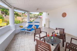 un patio con tavolo e sedie sul balcone. di Stromboli Suite Apartment with Terrace Volcano & Sea view a Stromboli